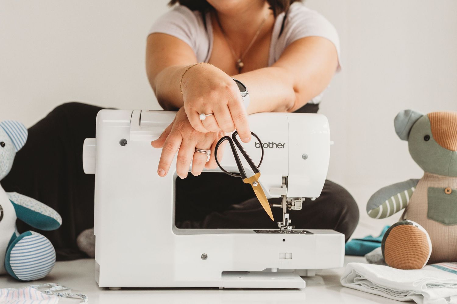 Close-up of hands working with sewing machine and fabric materials.