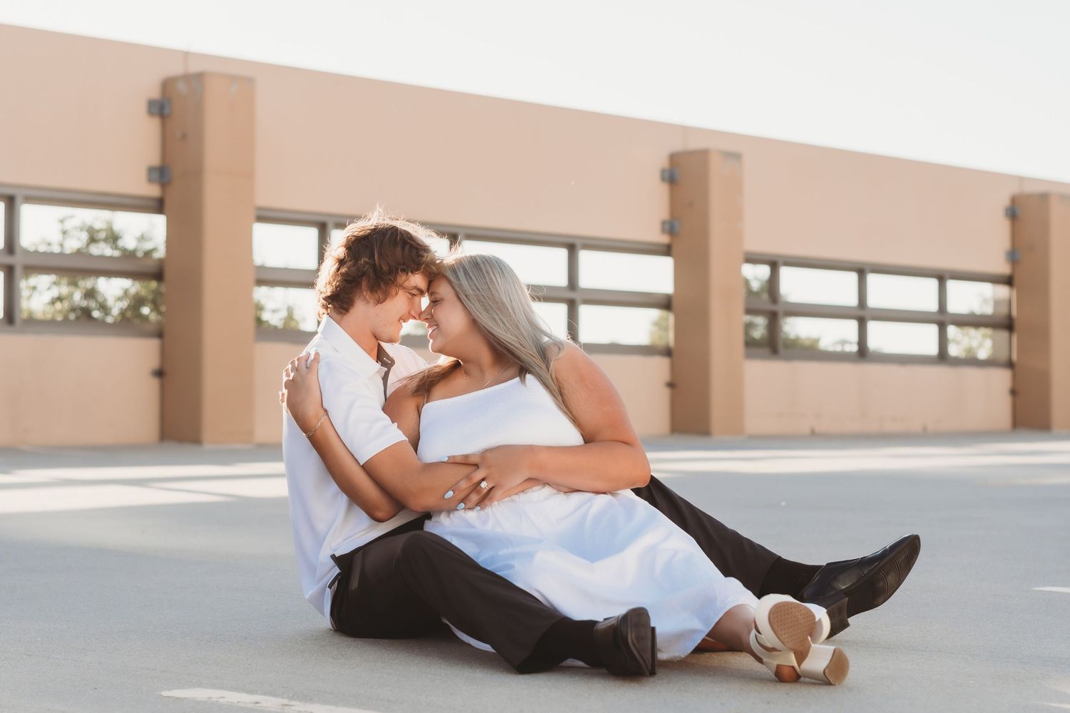 Couple dancing together in sunlit parking garage with romantic atmosphere.