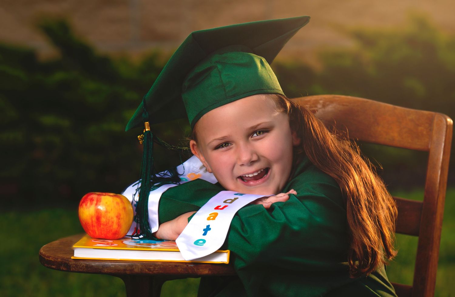 preschool graduation photo girl with desk and apple
