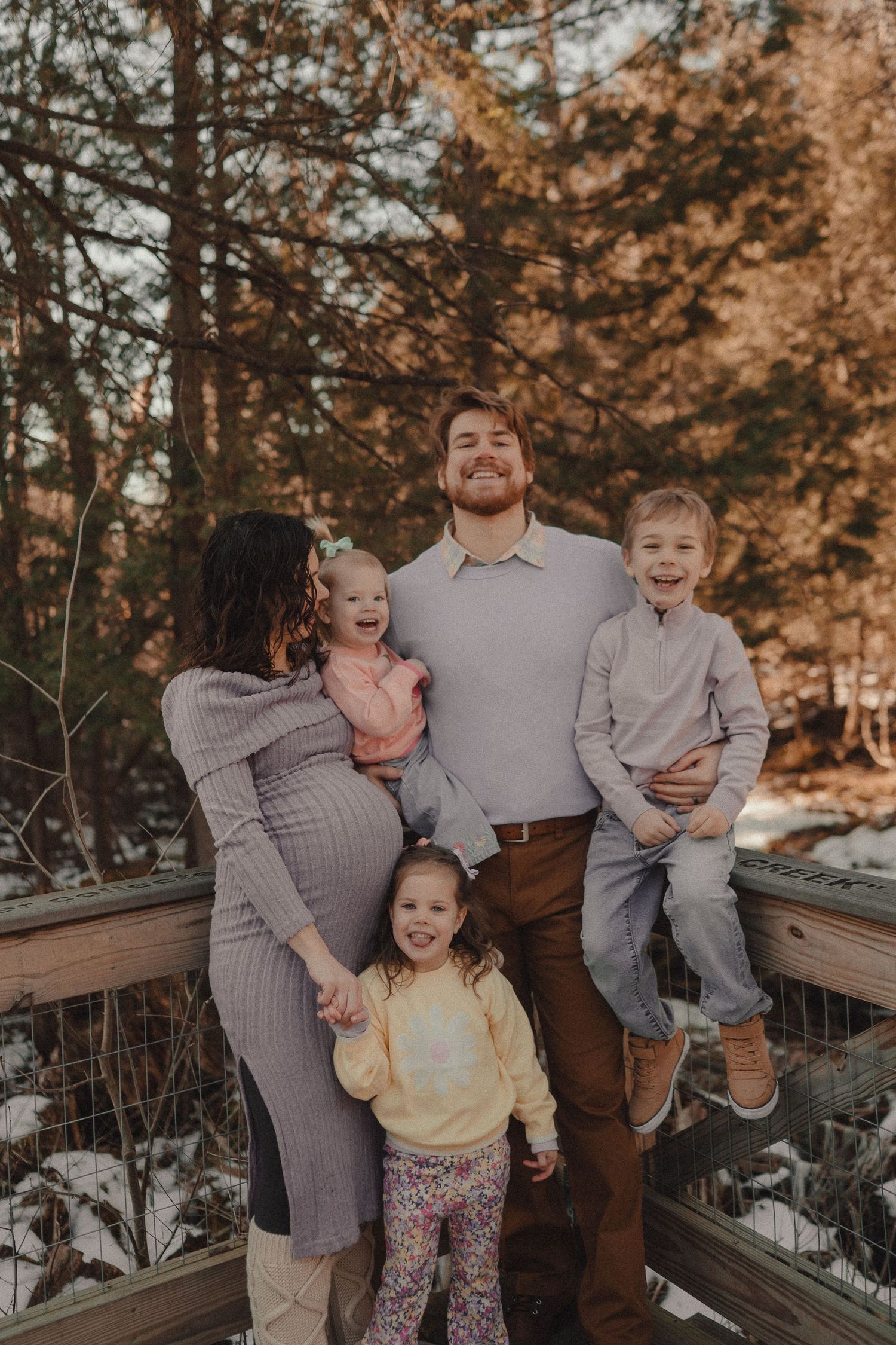 A joyful family photoshoot on a wooden deck during golden hour.