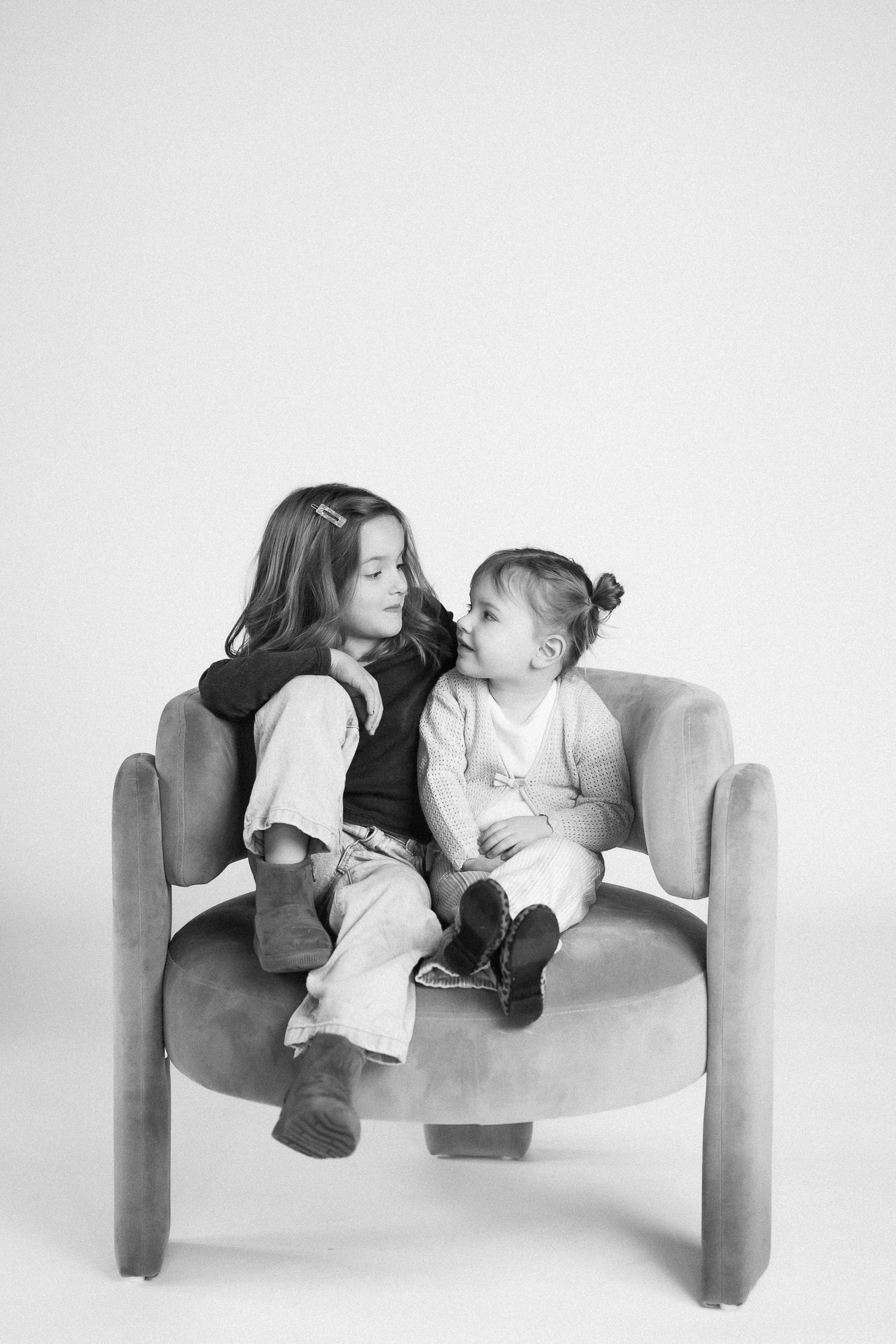 Black and white photo sequence showing tender moments between two people on a minimalist white bench.
