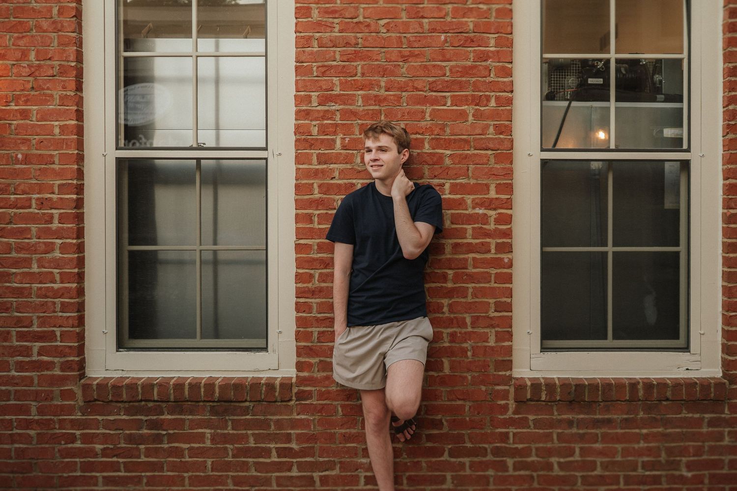 Series of casual poses against a red brick building with white-trimmed windows.