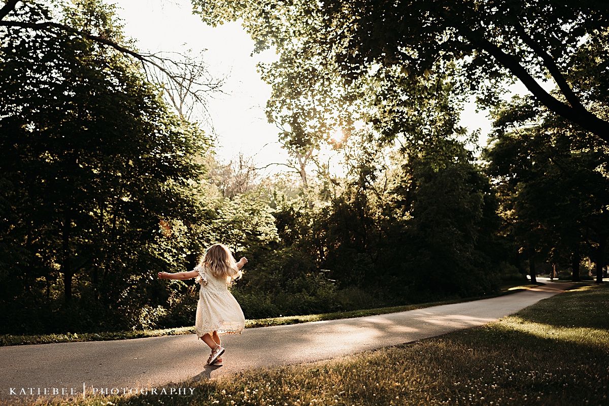 Silhouette of person dancing on path during golden hour sunset.
