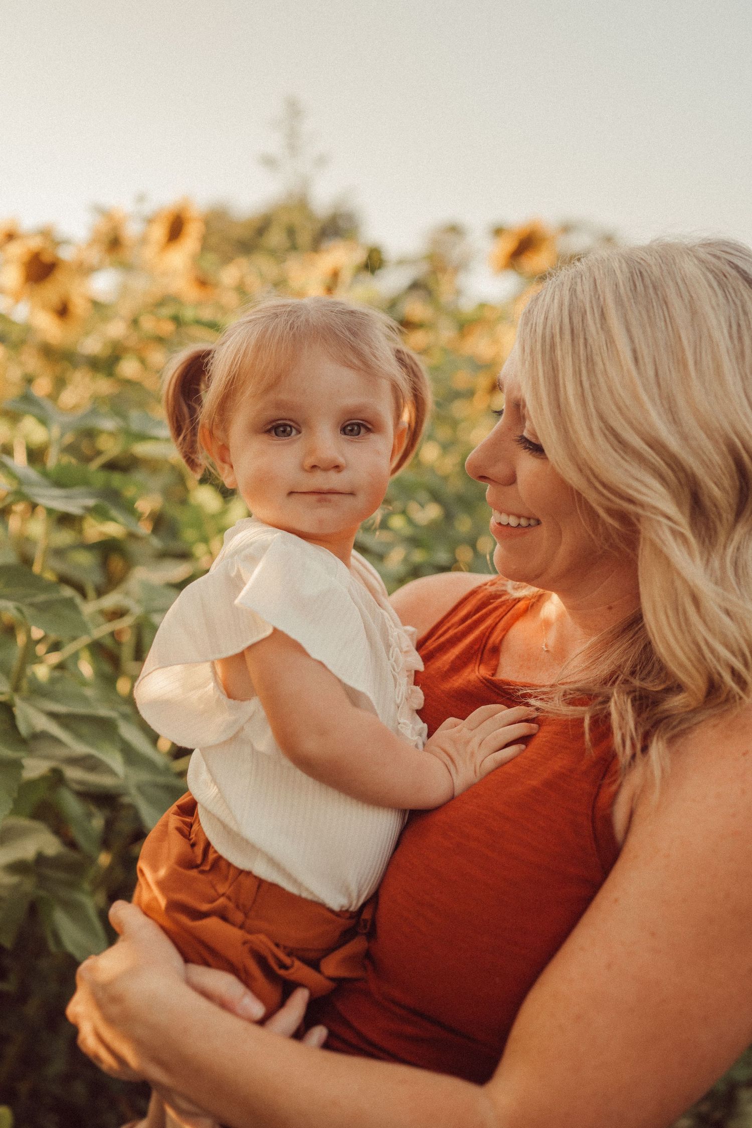 Sweet candid moment captured in a sunflower field at golden hour.