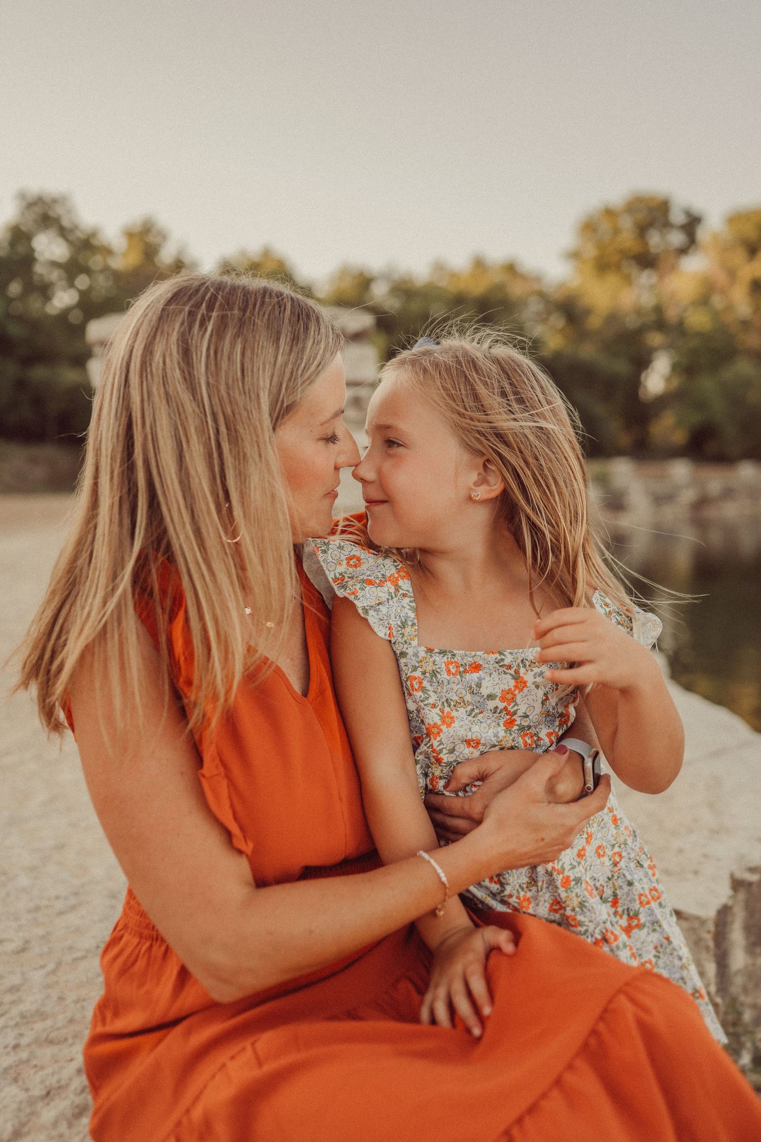 Intimate golden hour portrait showing tender affection against a lakeside backdrop.