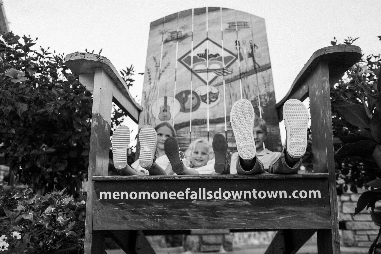 Vintage black and white signage and murals displayed on exterior building walls in a downtown area.