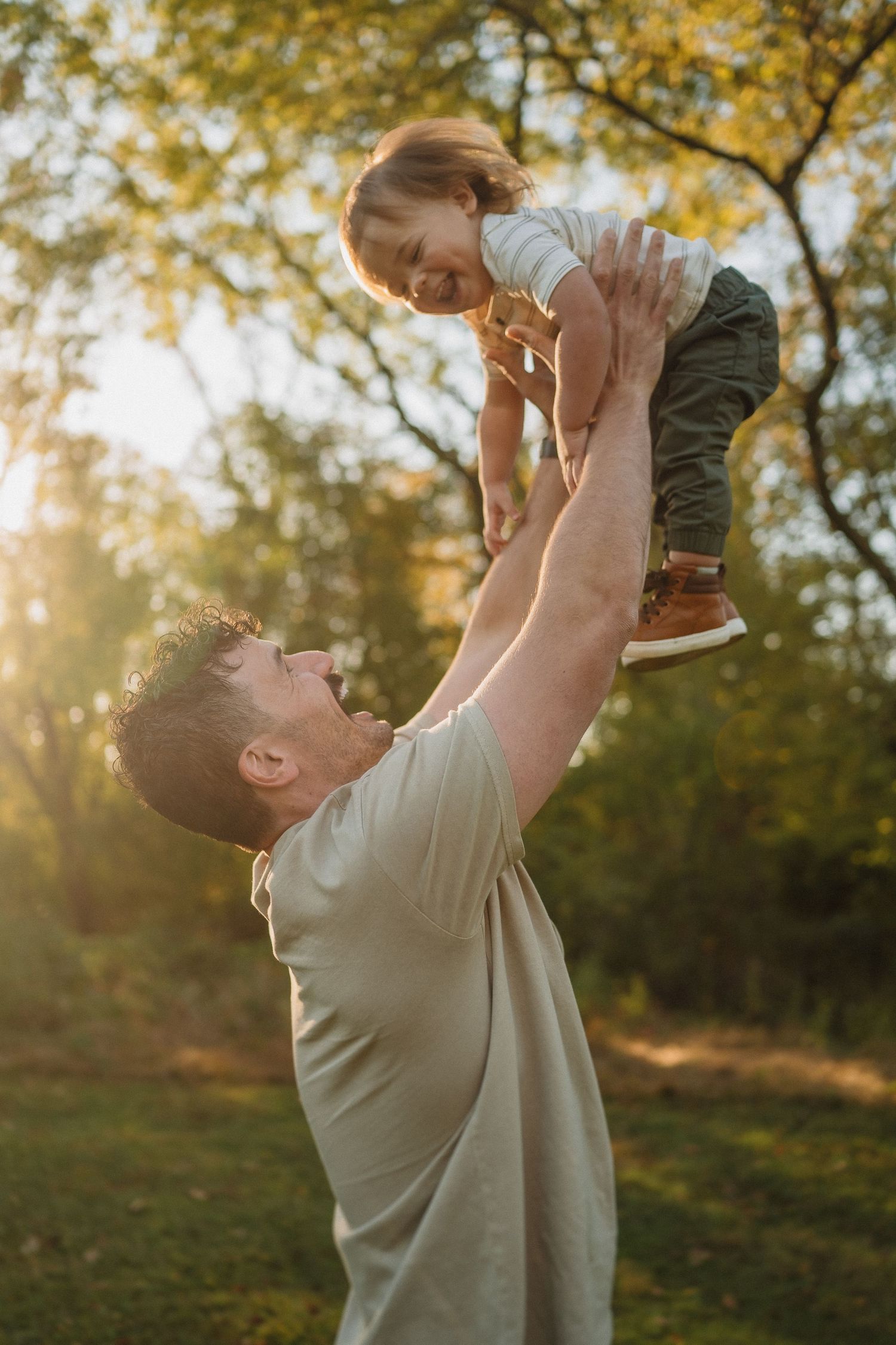 Joyful moment captured during sunset as a child is lifted into the air.