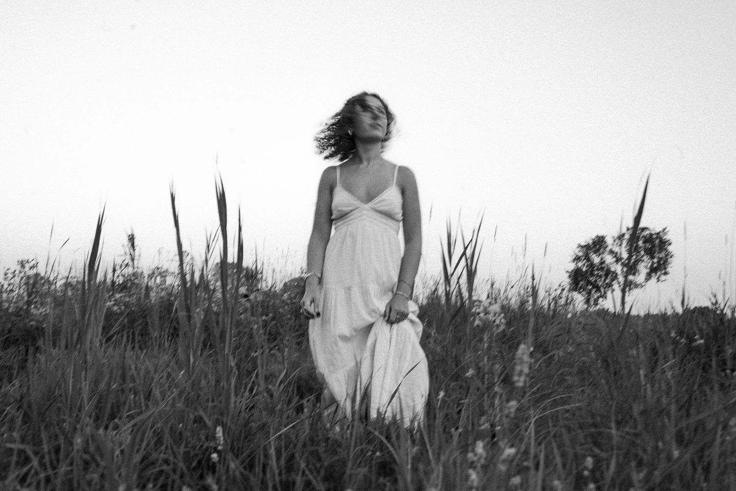 Atmospheric black and white photos capture movement through a wild grass field.