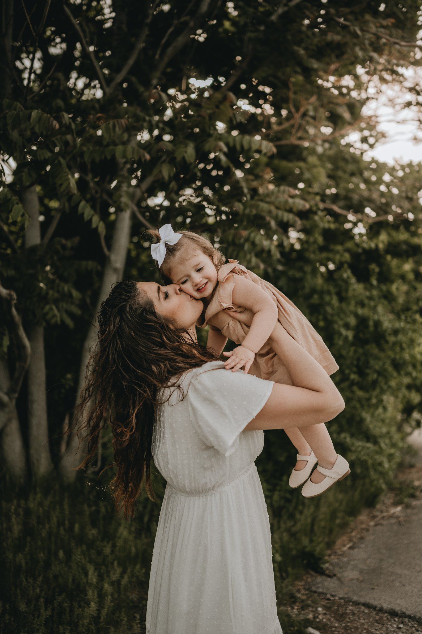 Joyful moment captured between parent and child playing and laughing in natural outdoor setting.