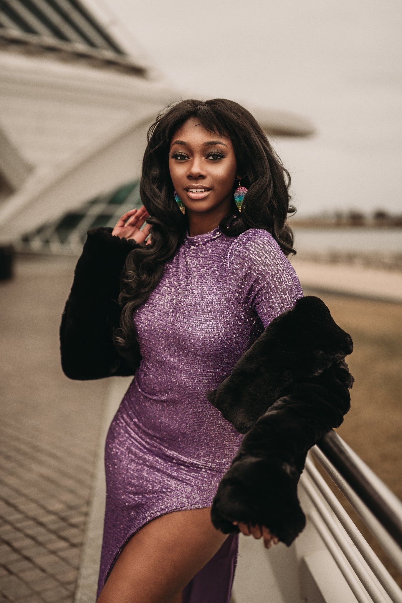Close-up portrait shot of a woman in a sparkly purple dress with a black fur coat.