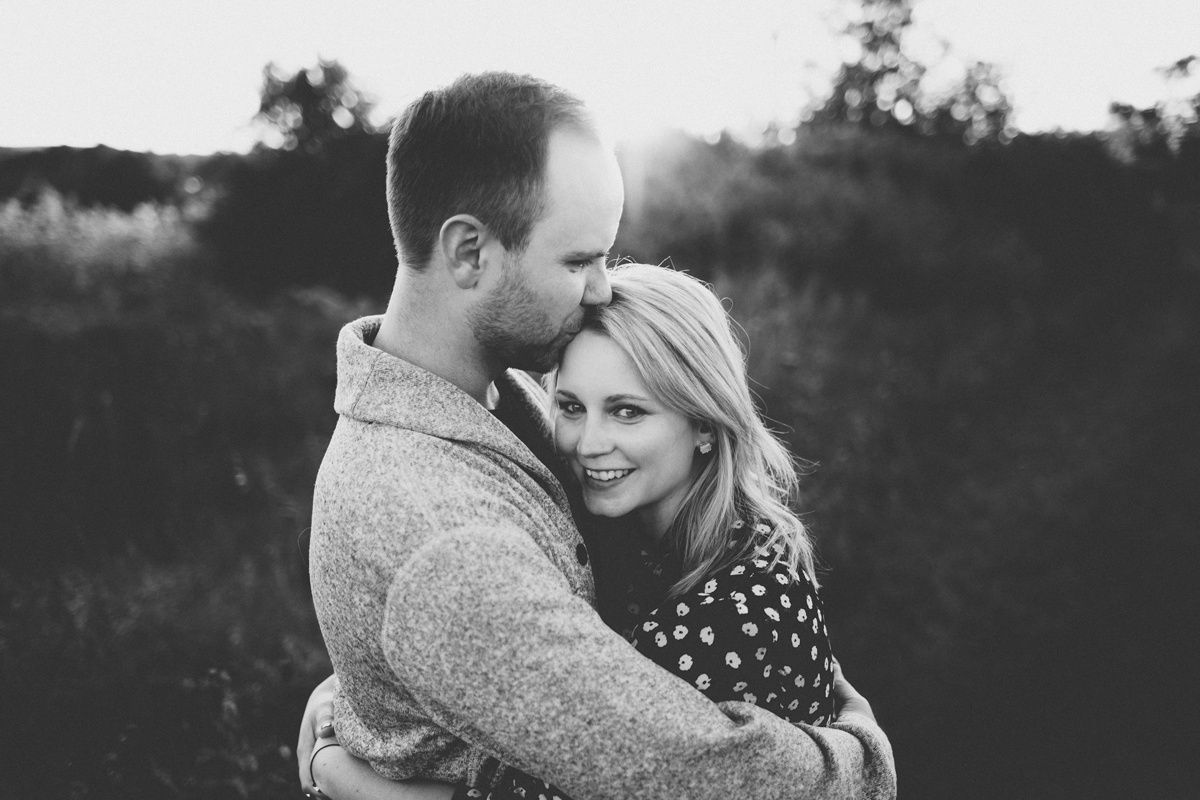 Black and white romantic portrait of couple embracing outdoors.