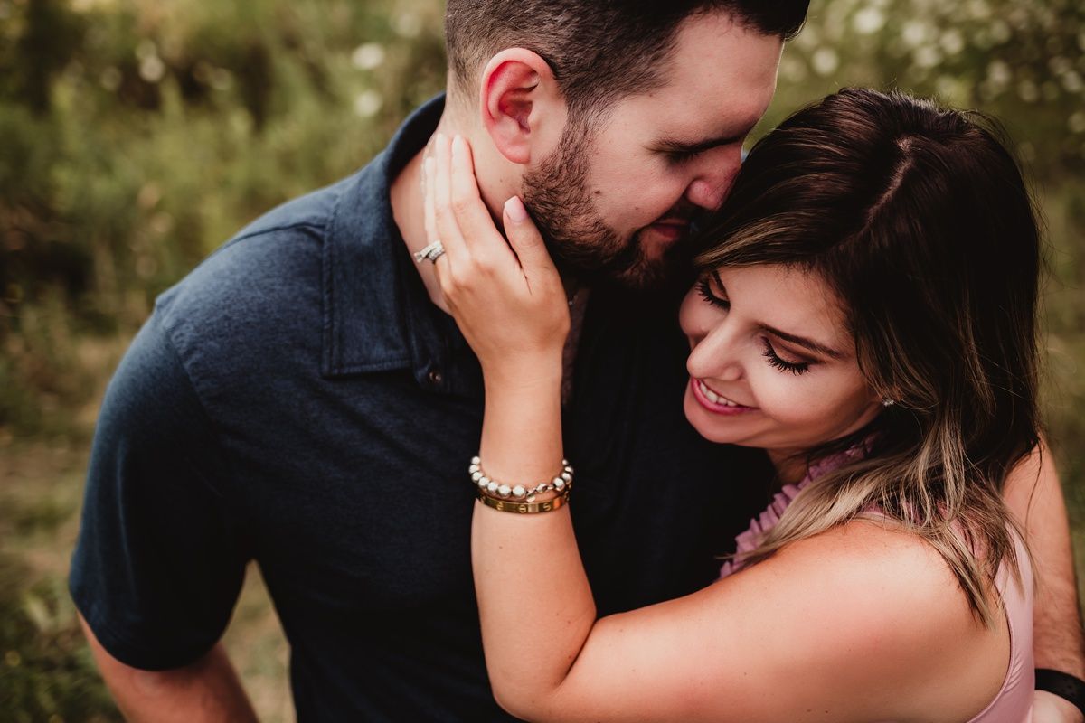 A romantic couple sharing an intimate moment during an outdoor photo session.