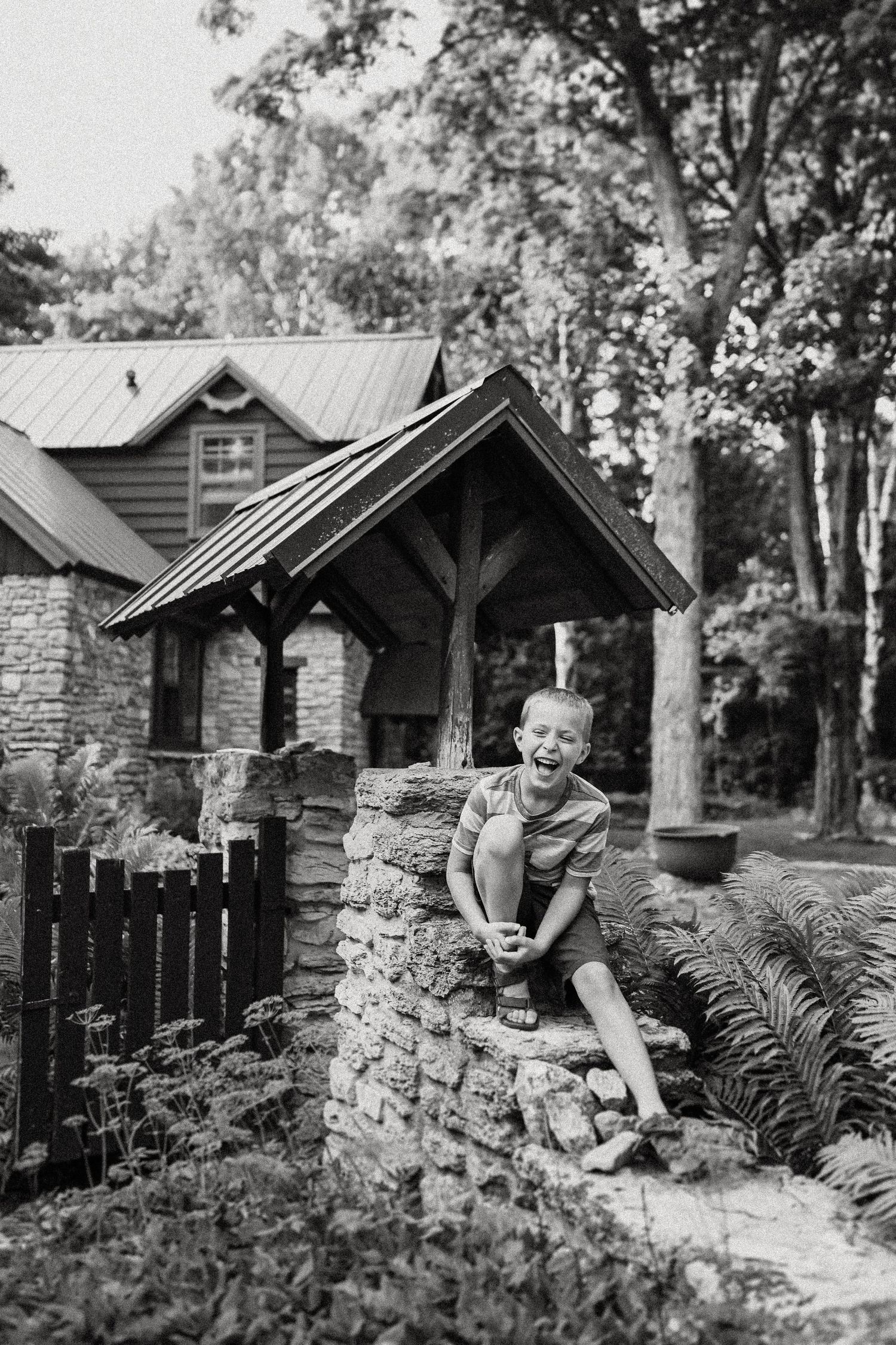 Black and white photo of a charming cottage with stone walls and timber frame details.