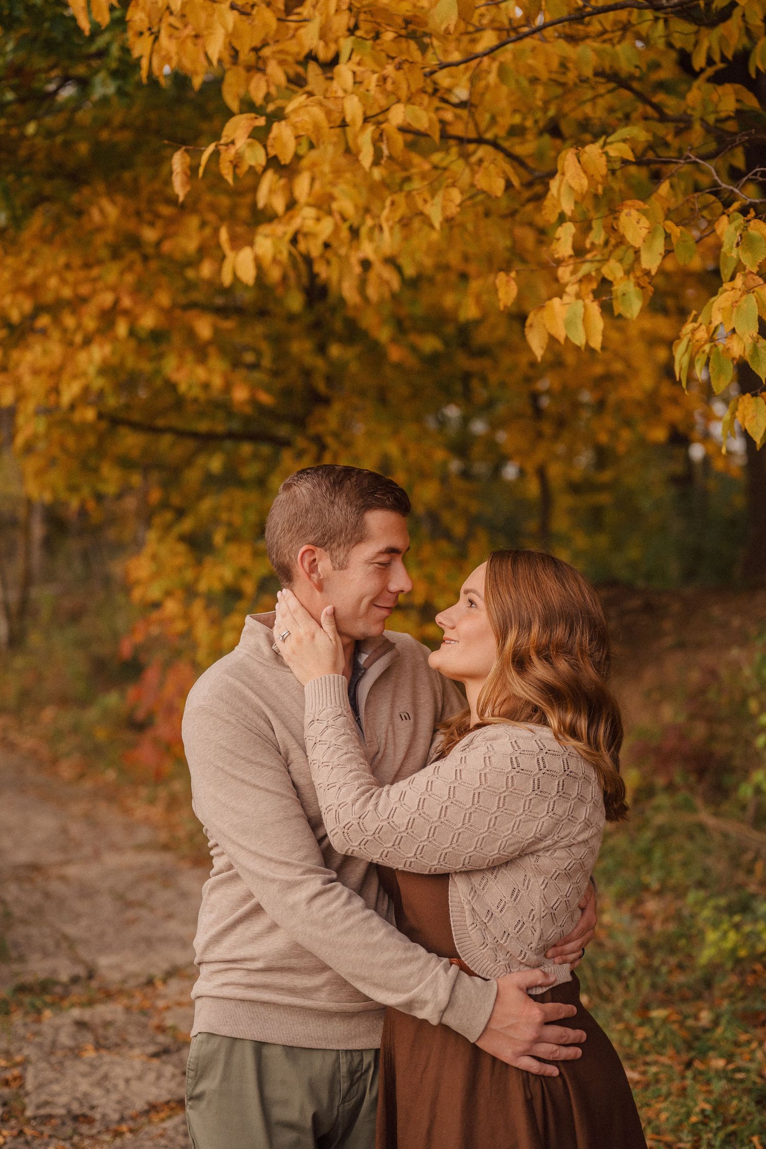 Romantic autumn couple photos with golden leaves in background showing intimate embraces and tender moments.