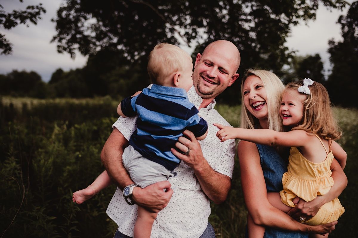 Candid family moment filled with laughter in an outdoor setting.
