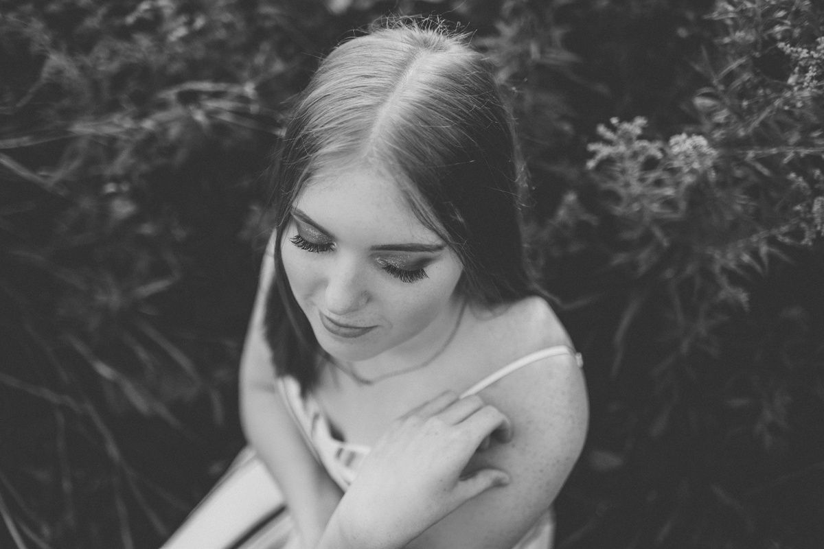 Black and white portrait of a person looking down with gentle expression.