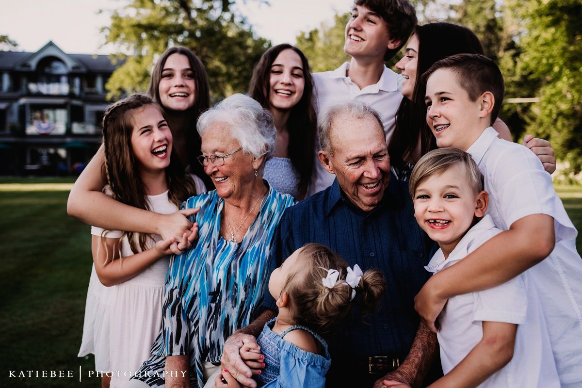 Candid outdoor portrait capturing genuine laughter during a multi-generational photoshoot.