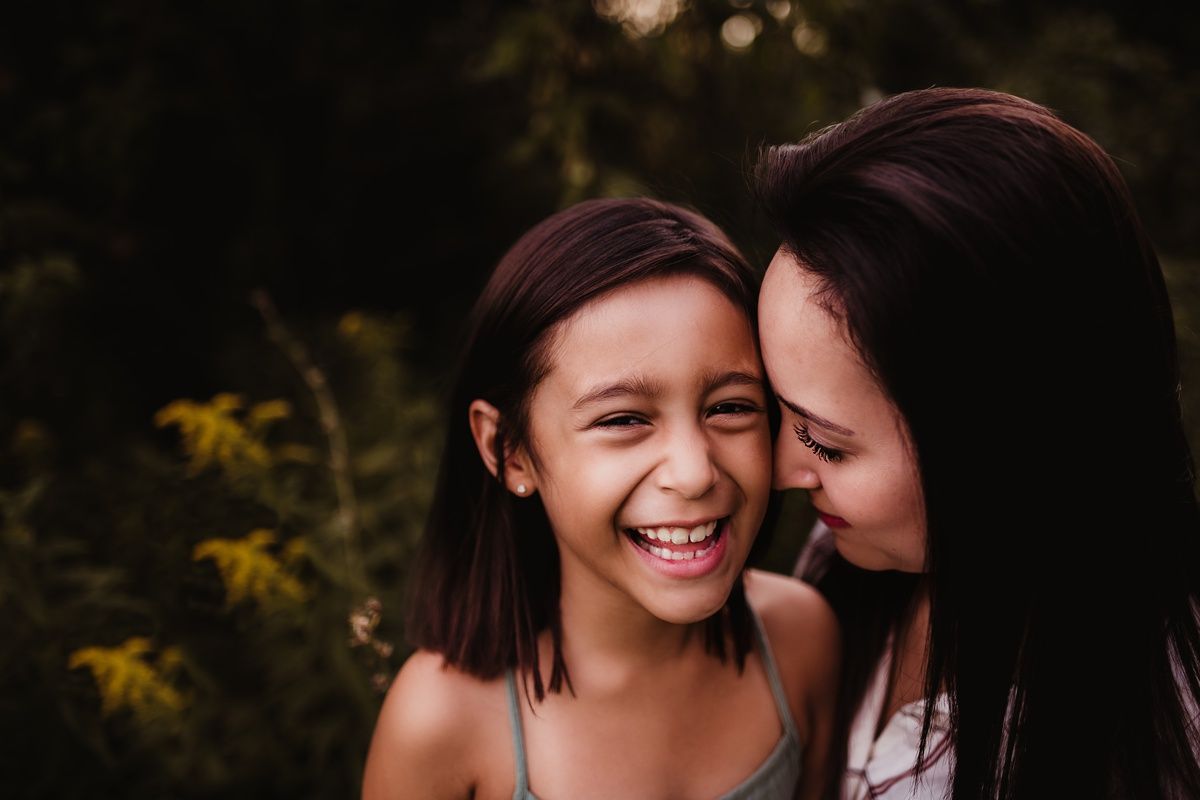 Candid moment of shared laughter and joy captured in warm evening light.