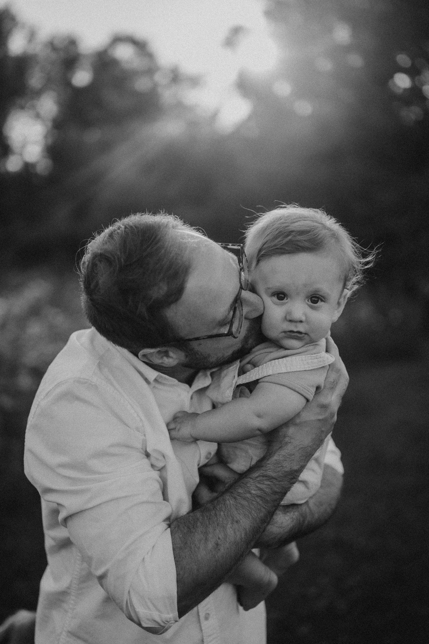 Intimate black and white portrait of tender moment between adult and baby.