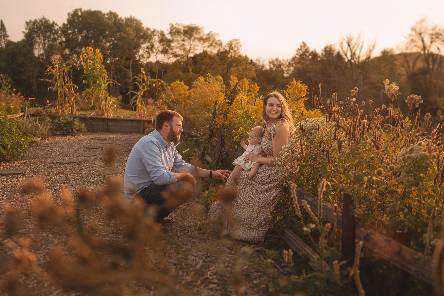 A romantic moment between a pair sitting in a golden-lit garden at dusk.