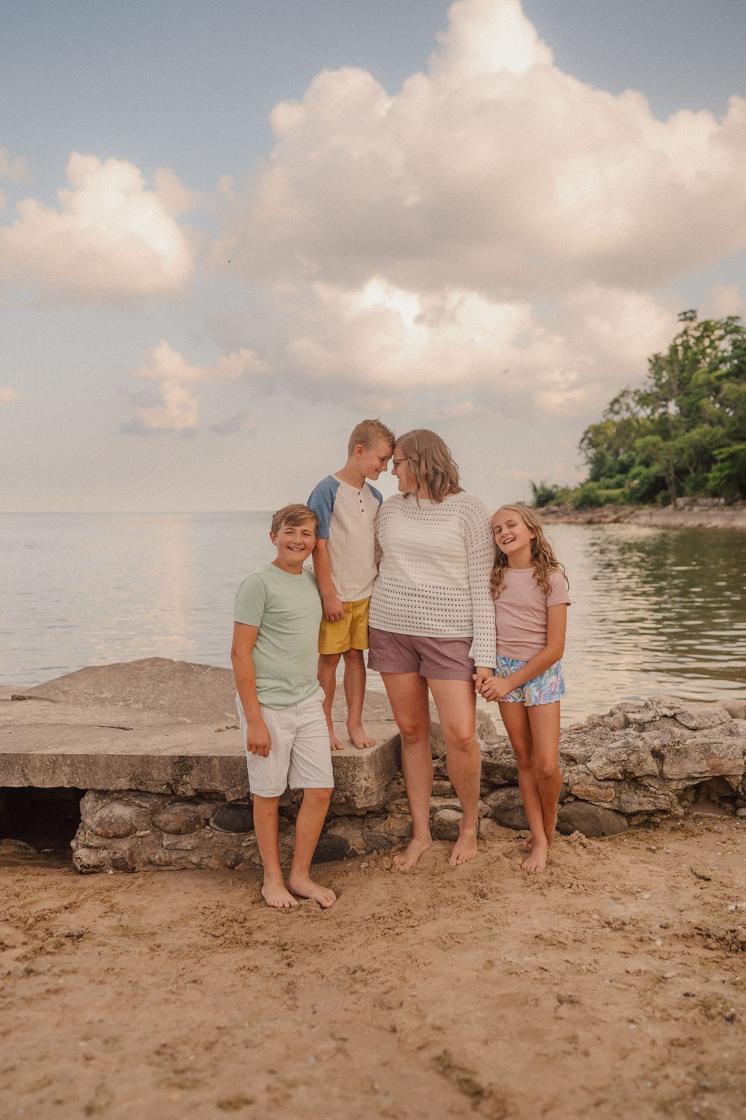 Group gathered on a rocky beach shoreline during golden hour.