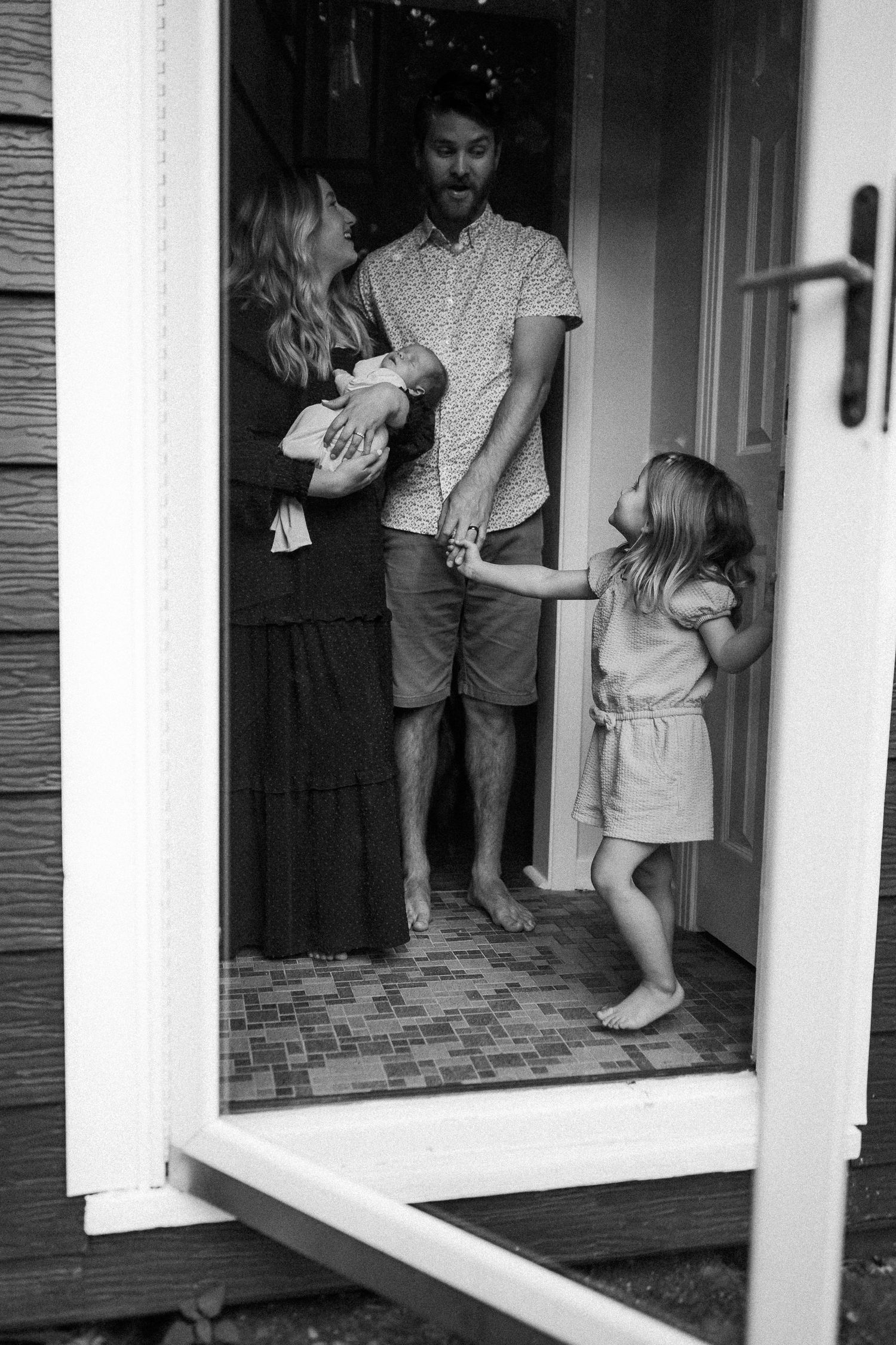 Black and white doorway portraits showing tender family interactions.