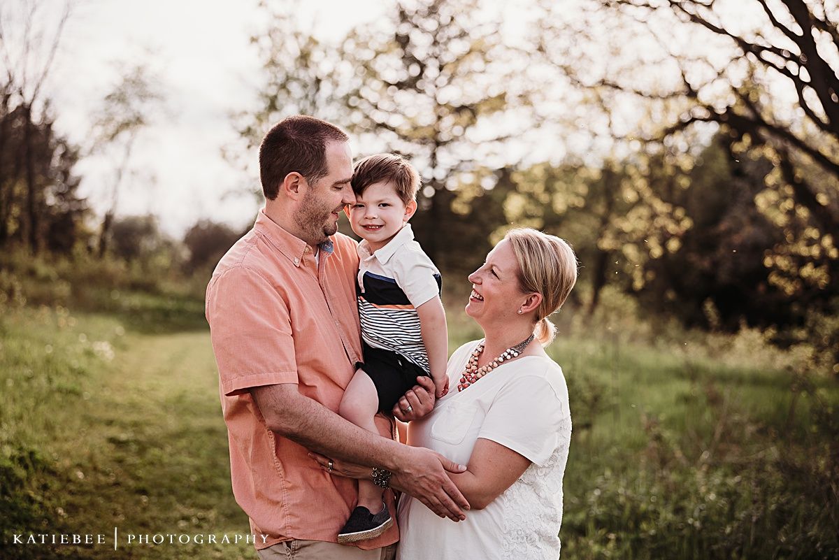 A touching outdoor family portrait showing warmth and connection against a natural backdrop at golden hour.
