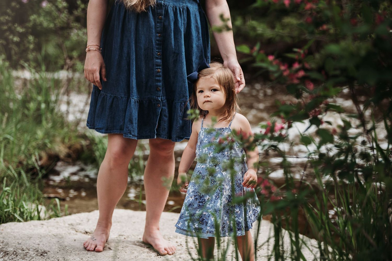 Standing barefoot on garden stones wearing flowing summer dresses.