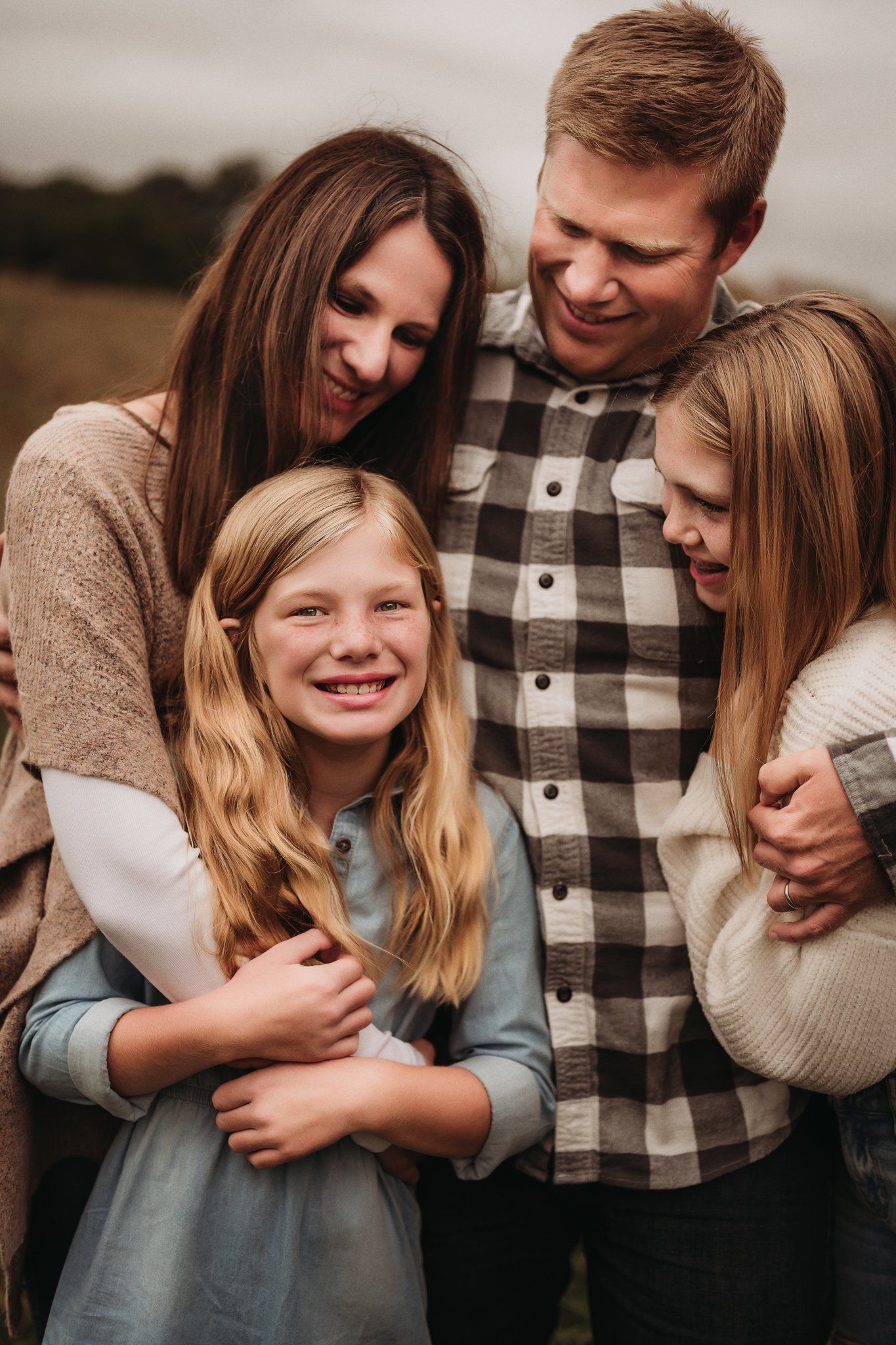 Intimate family portrait showing genuine emotion and laughter in warm lighting.