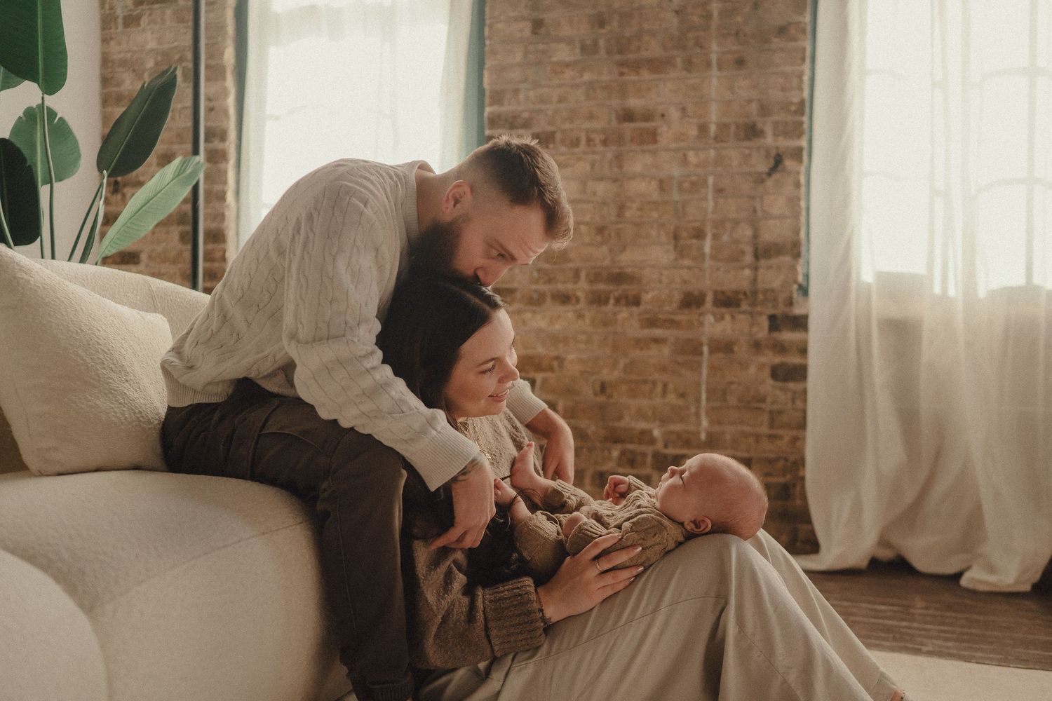 A series of romantic moments between a couple in a cozy brick-walled room with natural lighting.