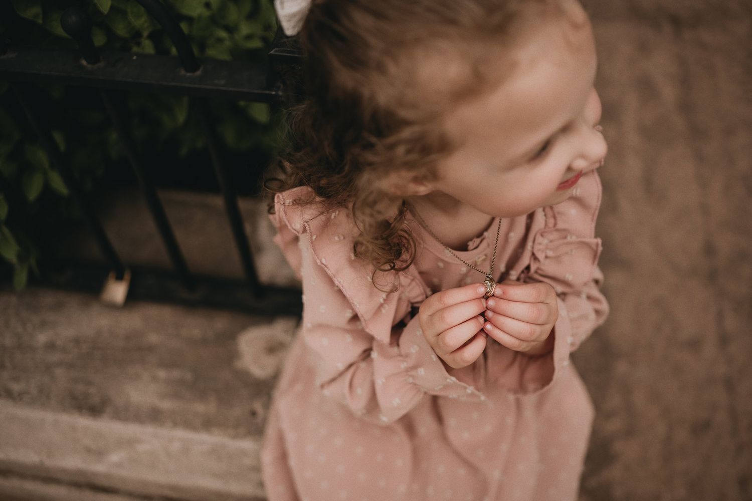 A candid moment of joy captured as a child in a pink dress laughs heartily.