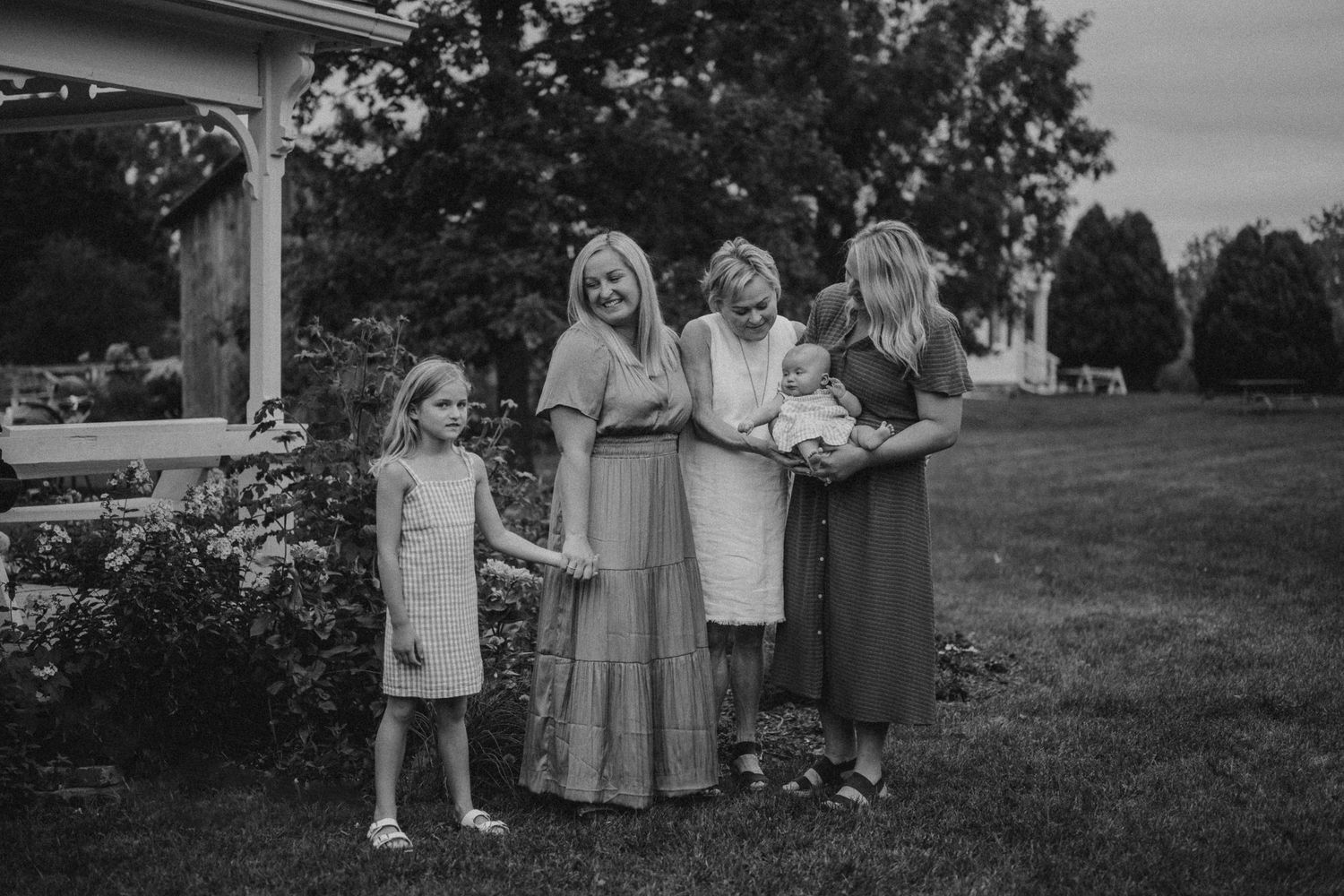 Black and white portrait of family members standing together in a garden with roses.