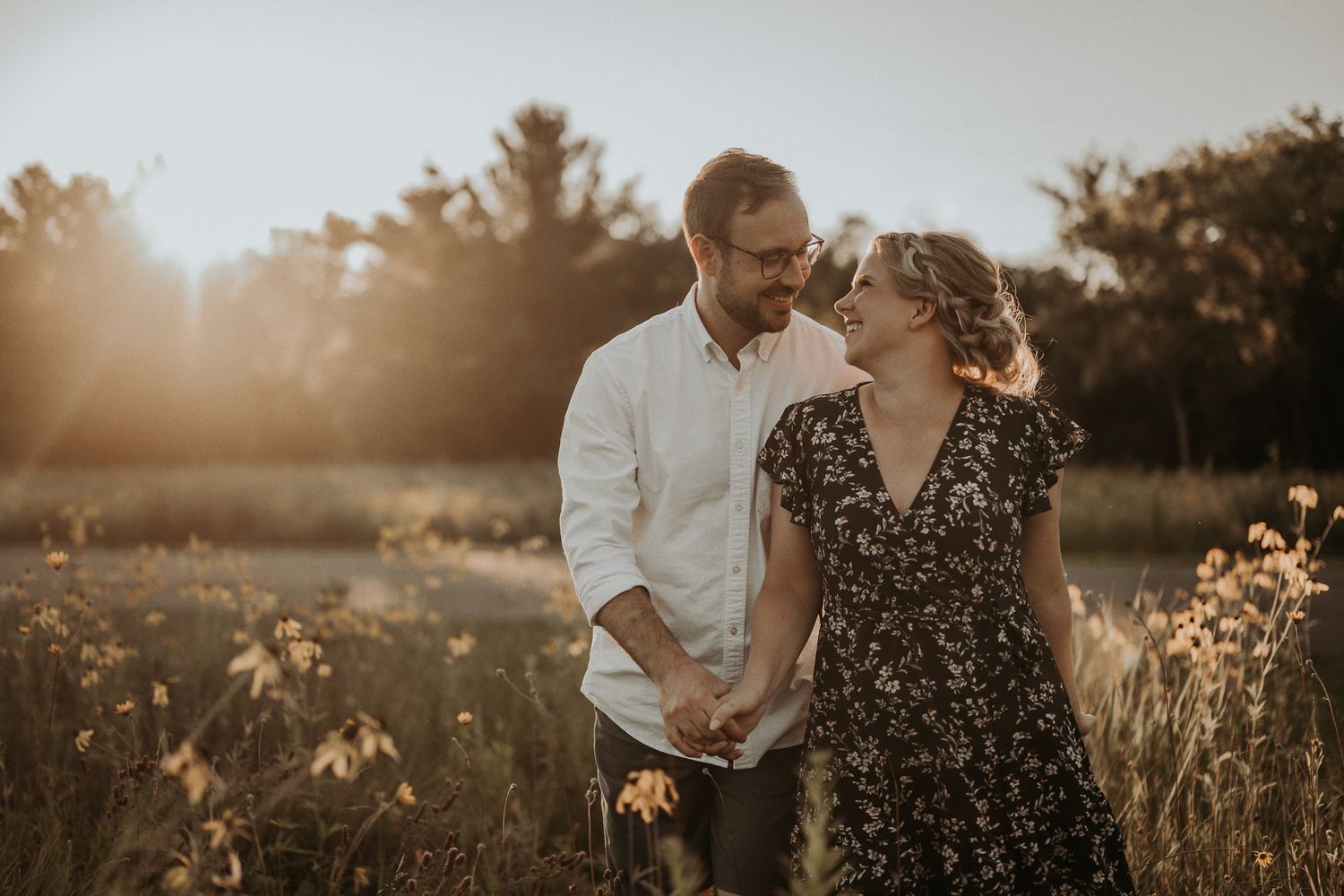 Happy couple sharing intimate moment in sunlit summer meadow.