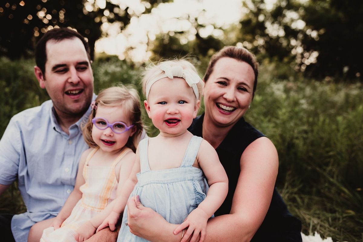 A happy family portrait taken outdoors during golden hour.