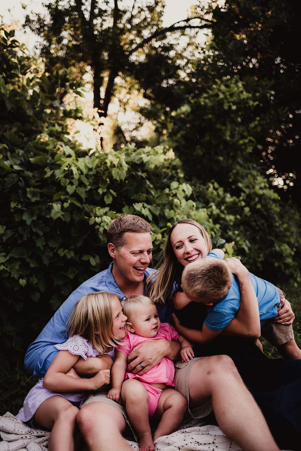 Candid family moment filled with laughter during outdoor photo session.