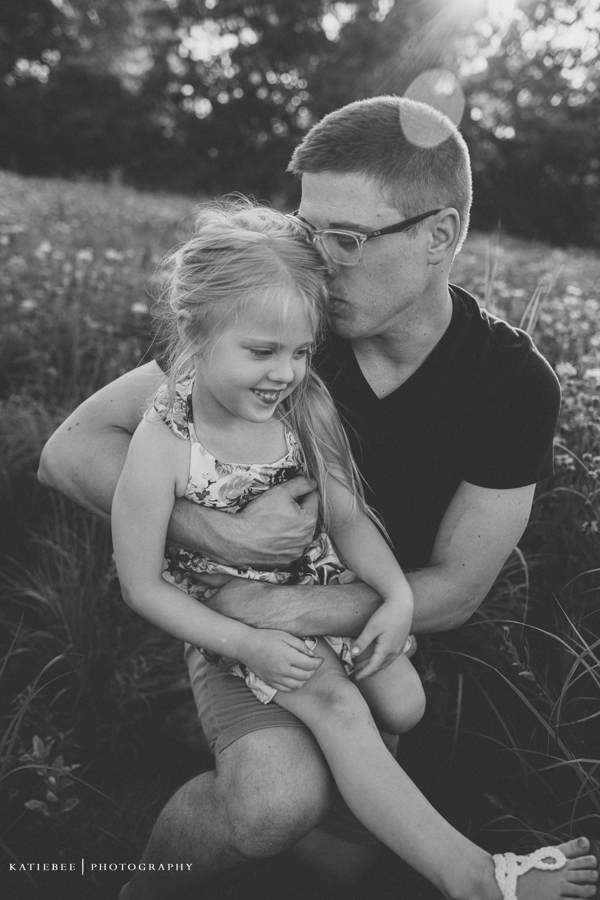 Sweet candid black and white portrait in wildflower field showing tender moment.