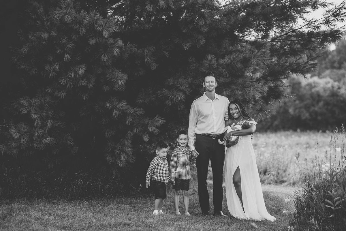 Black and white family photo showing group walking together through a meadow.
