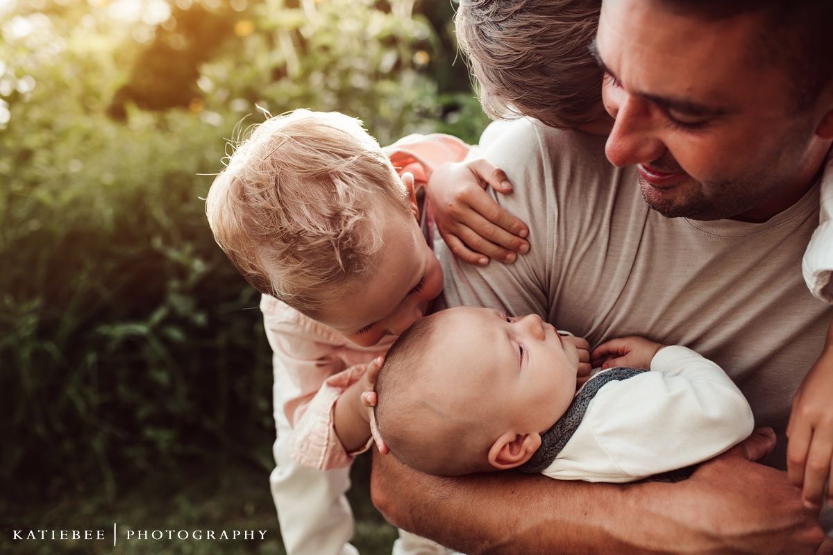 Sweet candid moment of family bonding outdoors in golden sunlight.