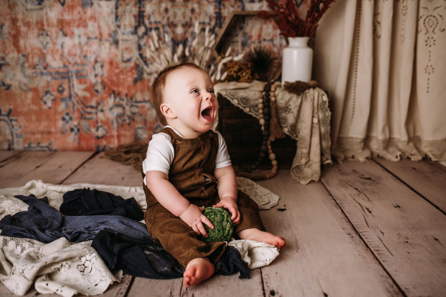 Joyful expression while holding green prop against vintage brick wall setting.