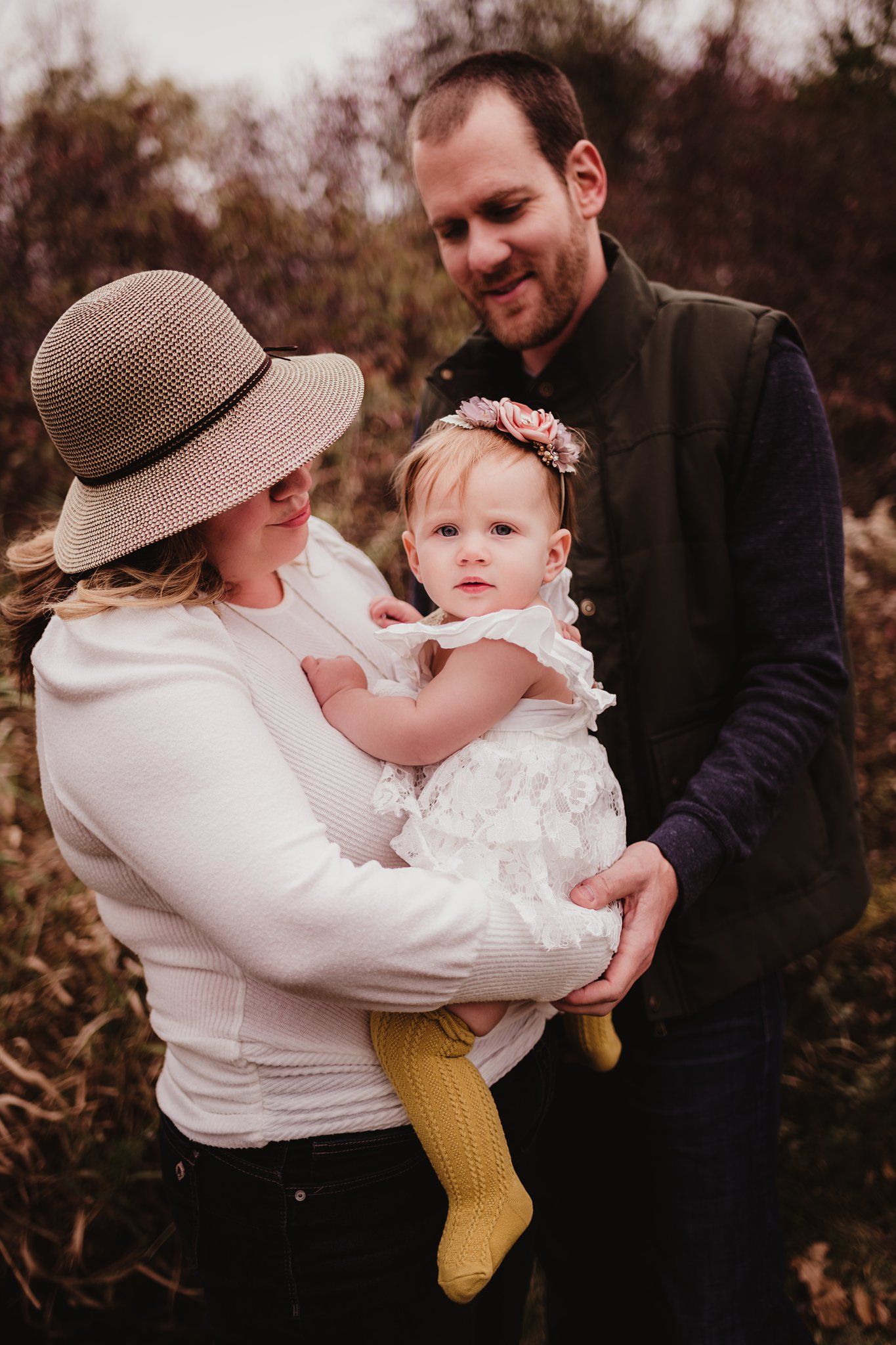 Family portrait in autumn field with soft natural lighting.