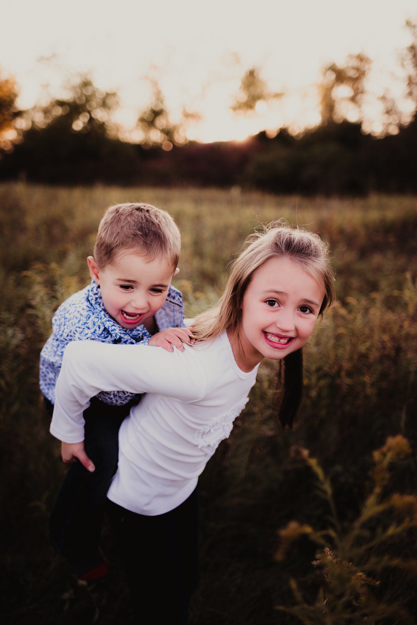 Playful piggyback ride moment captured at sunset in a field.