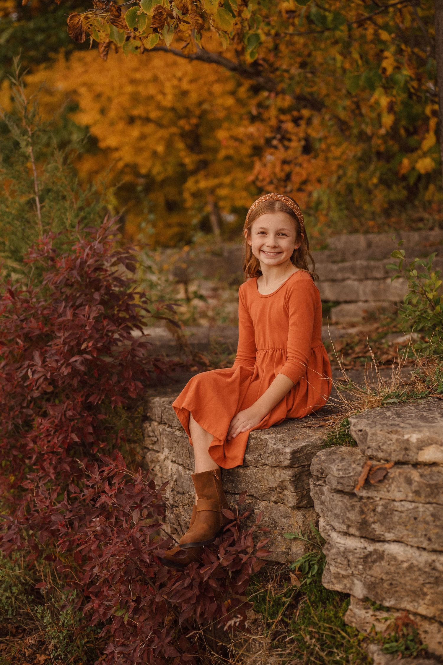 A rustic stone wall creates a natural backdrop against vibrant fall colors and foliage.