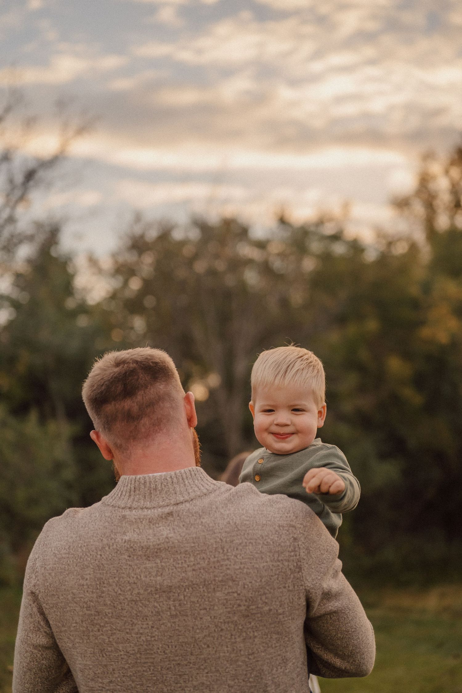 Tender moment between parent and child against sunset backdrop.