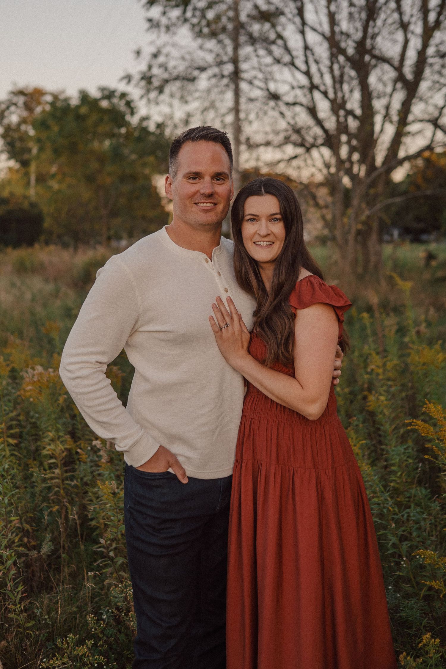 Romantic outdoor photo session in a wildflower field at sunset with rustic autumn styling.