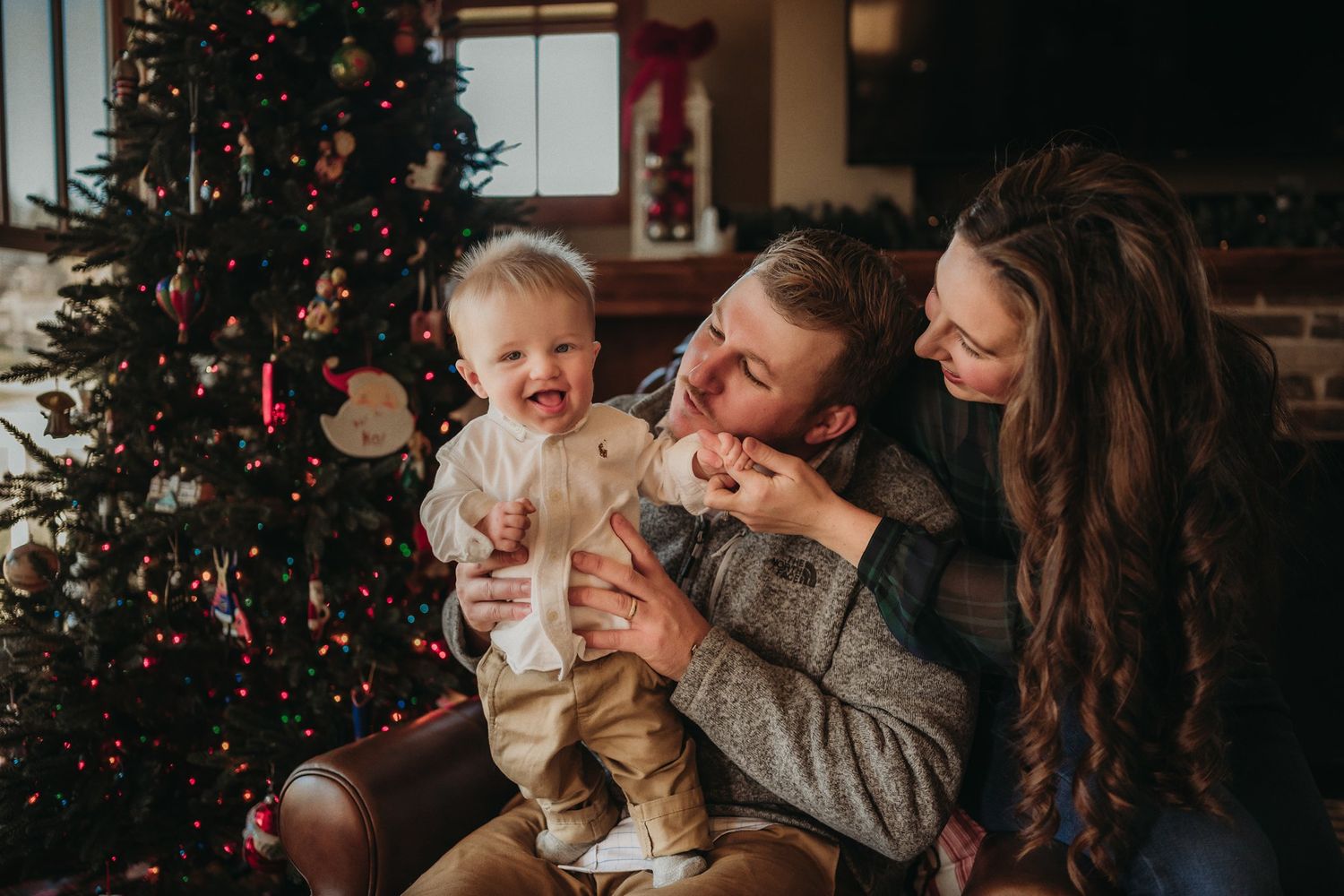A happy family shares laughter and cuddles during their Christmas photo session.