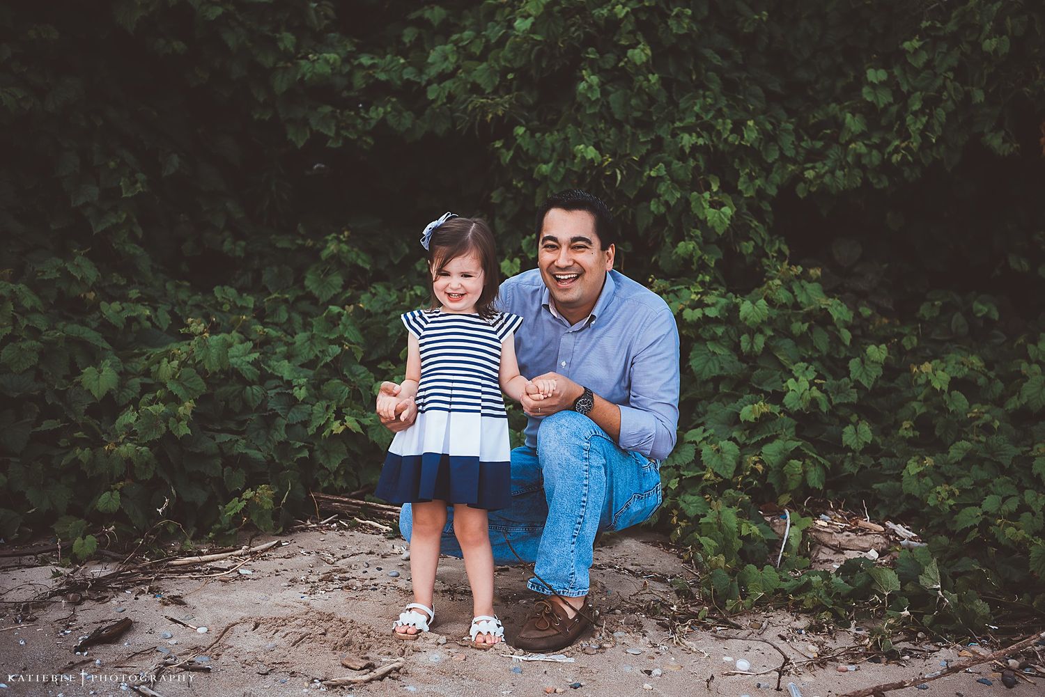 A joyful outdoor moment captured between parent and child on a rocky outcrop.