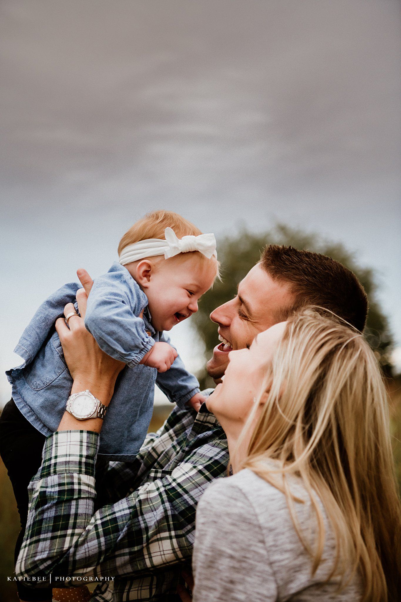 Joyful family moment captured during outdoor photoshoot in golden afternoon light.