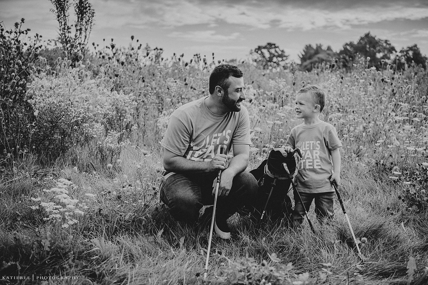 A heartwarming black and white photo of a parent and child bonding outdoors in a meadow.