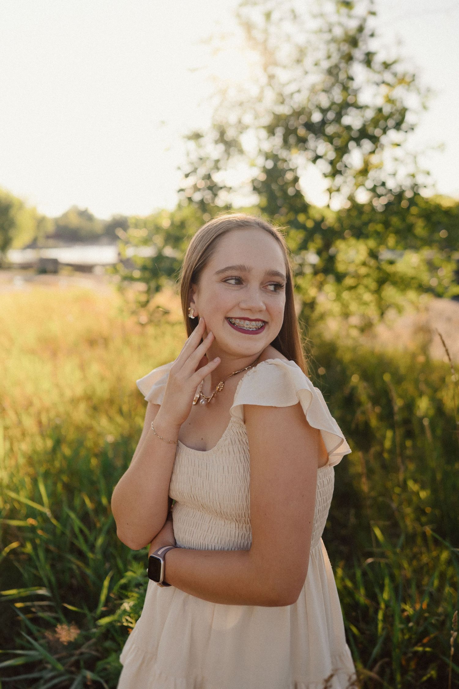 A series of candid outdoor portrait shots in a golden field at sunset showing joyful expressions and laughter.
