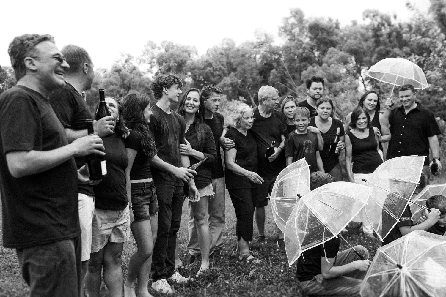 Group celebration in black attire with flowing fabric creating dynamic movement outdoors.